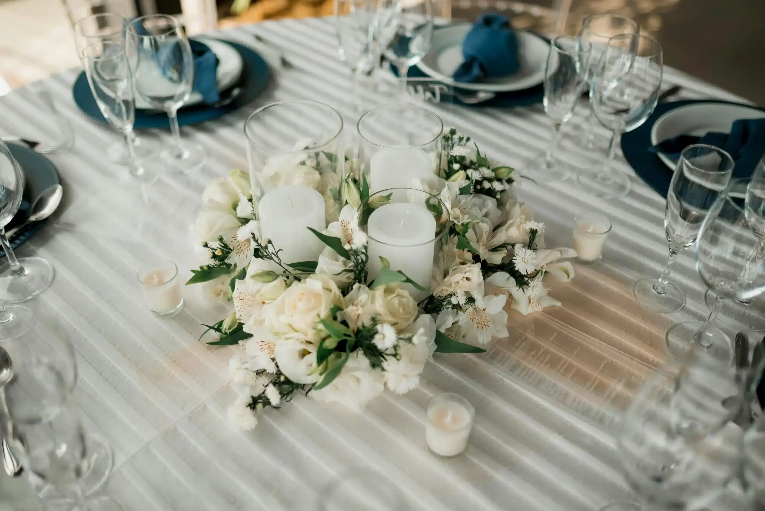 Idea de centro de mesa original con velas y flores, utilizando velas, frutas y elementos de cristal.