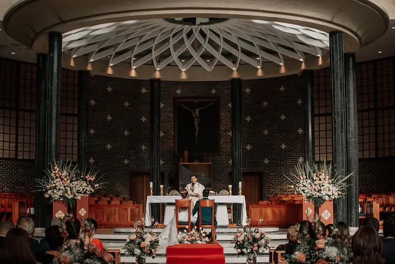Ceremonia de bodas católica en Bogotá dentro de una iglesia con decoración floral elegante para una celebración sagrada
