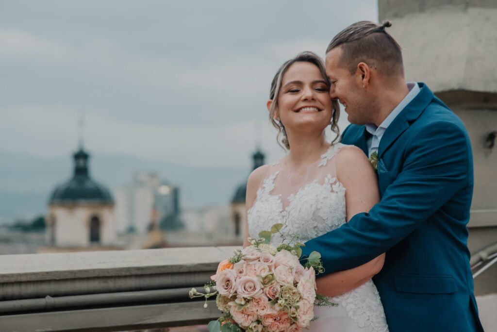 Novios felices abrazándose en el balcón durante su boda en la cuidadv de cartagena Colombia