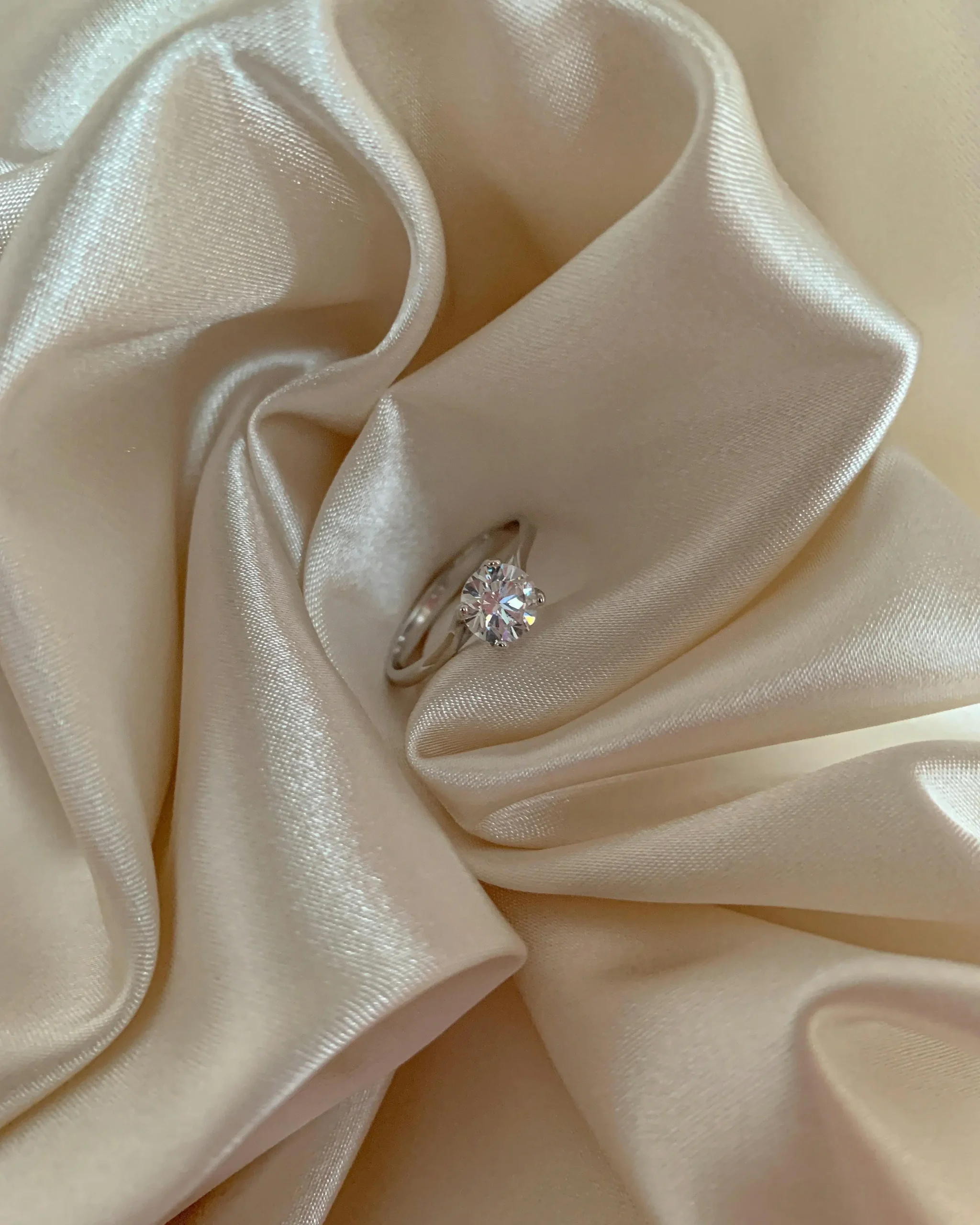 Anillo de compromiso sobre tela de seda, símbolo de amor en el aniversario de bodas de seda