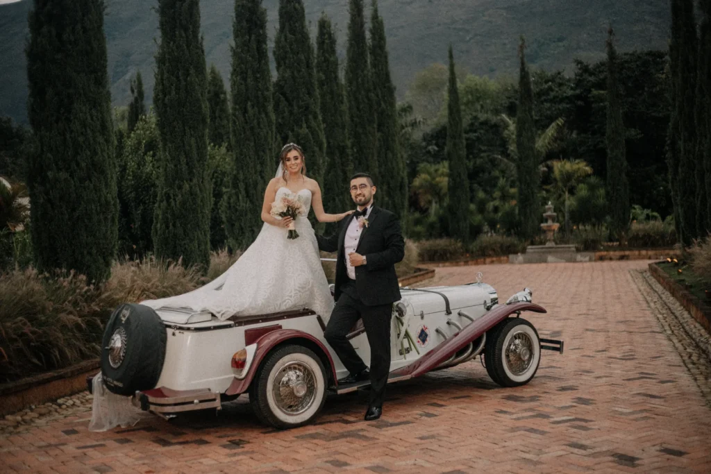 Pareja de recién casados en carro clásico celebrando sus bodas en Villa de Leyva