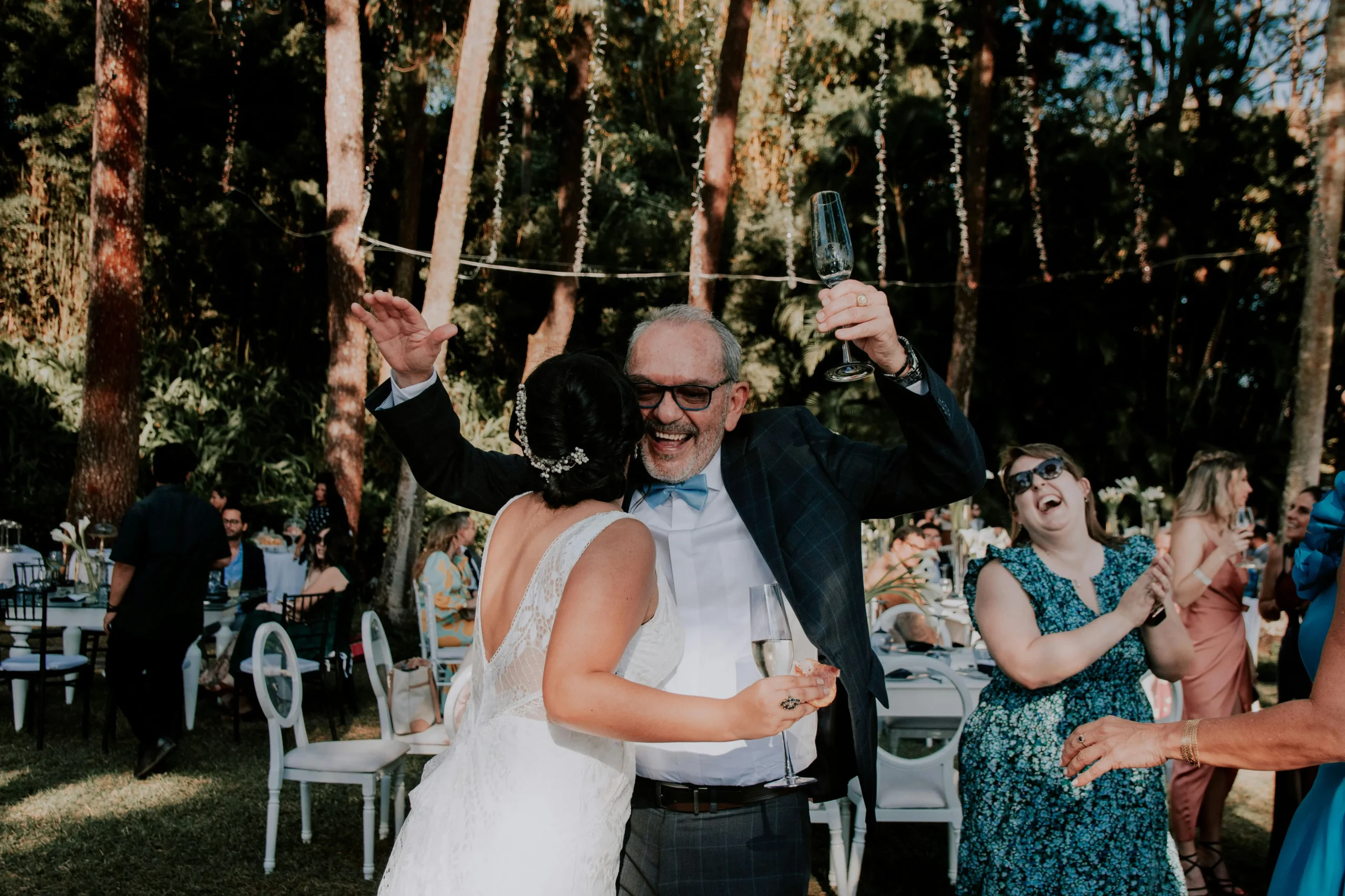 Tradiciones de bodas colombianas: padre y novia bailando felices durante una boda al aire libre en Bogotá, Colombia.