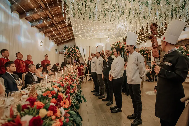 Equipo de chefs presentando un banquete en un evento con una mesa decorada y comensales