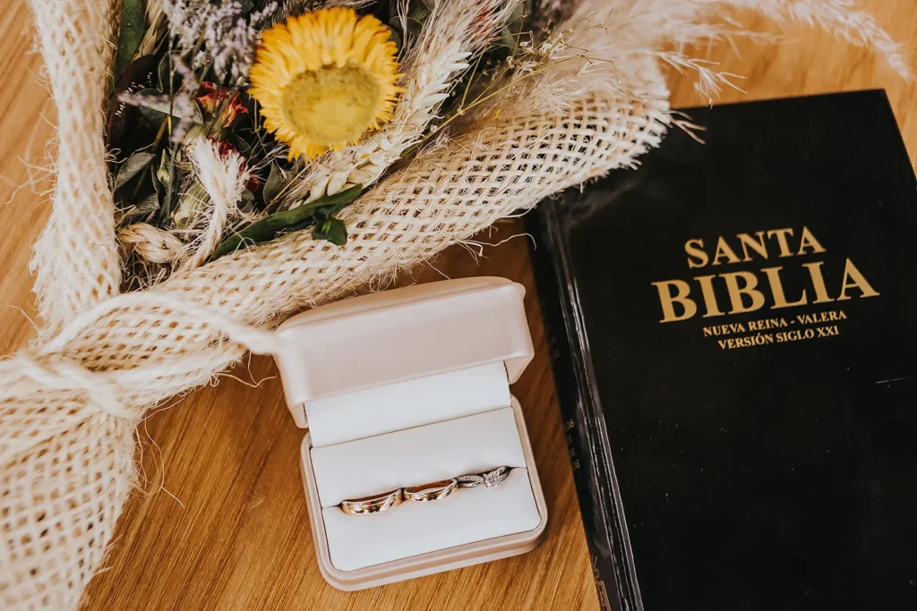 Detalle de Santa Biblia y anillos, símbolo de fe en bodas cristianas en Bogotá