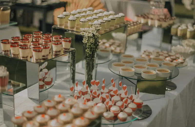 Mesa de postres variados para eventos en Bogotá, incluyendo cupcakes y mini postres en vasitos, ideal para celebraciones