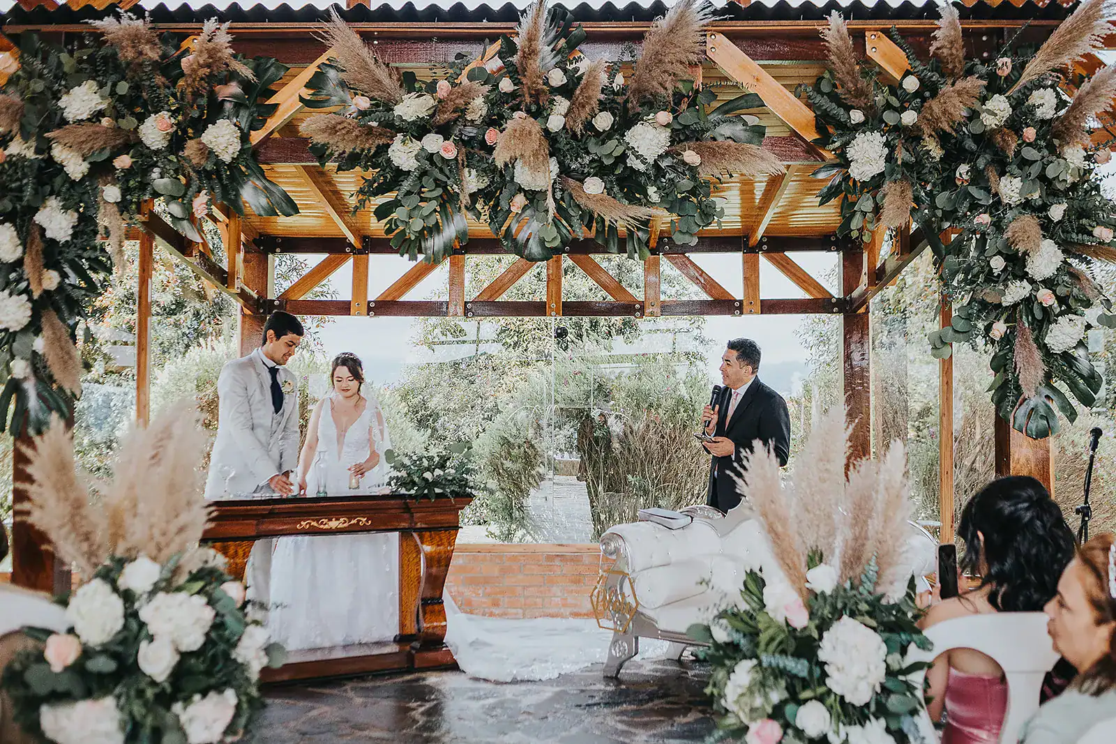 Novios intercambiando votos en altar decorado con flores – bodas espirituales en Colombia