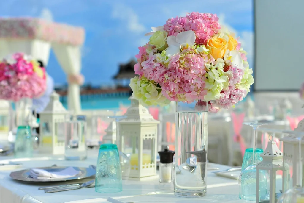 Mesa decorada con flores rosadas y amarillas en una boda elegante al aire libre, ideal para bodas en San Andrés.