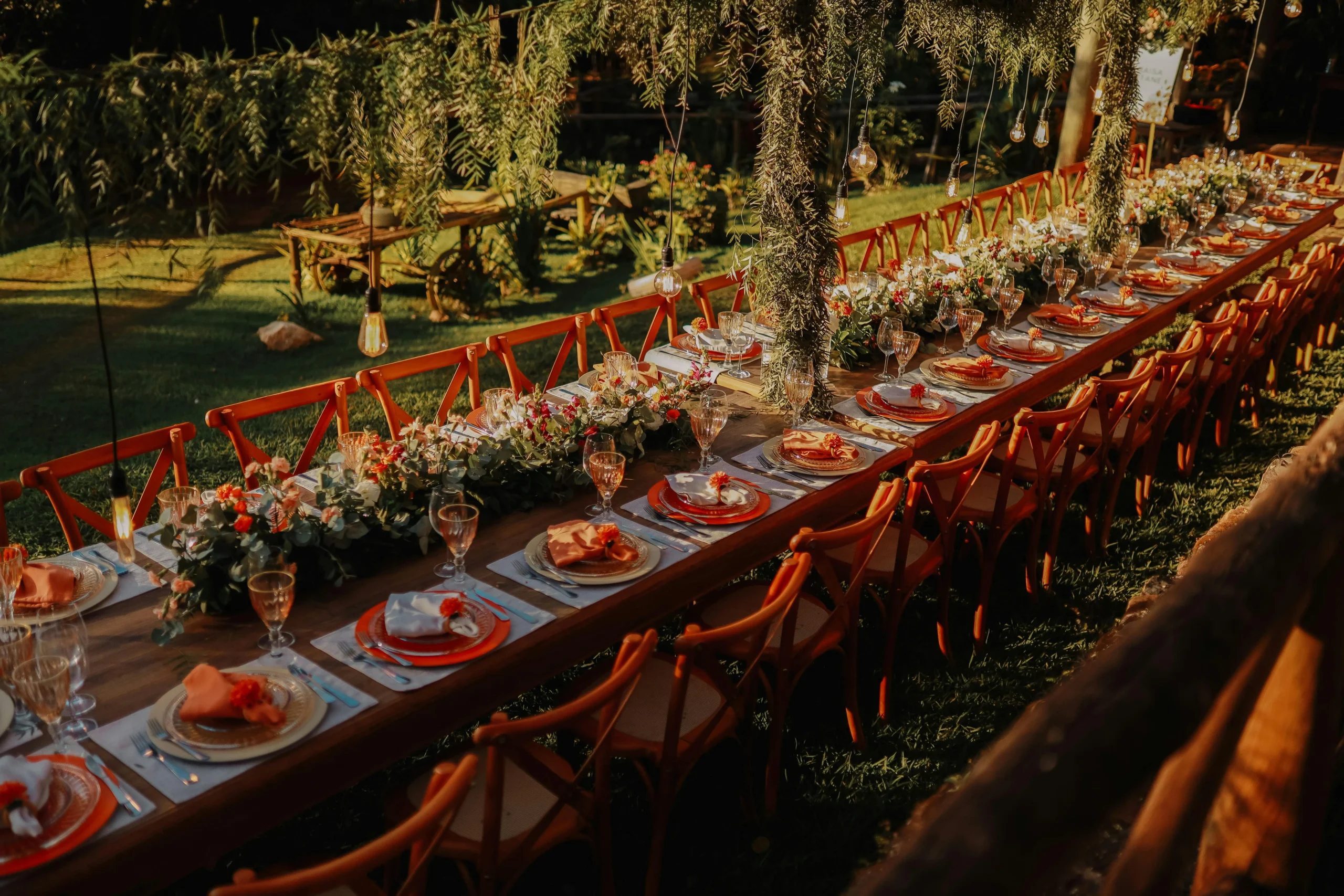 "Mesa larga de banquete elegantemente decorada con flores y vajilla para un evento campestre o al aire libre en Bogotá.
