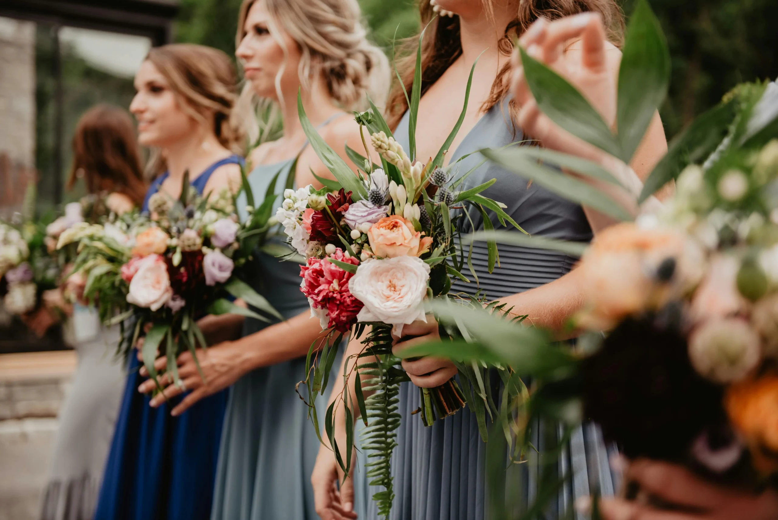 Damas de honor elegantemente vestidas sosteniendo sus ramos de flores, parte esencial del protocolo de una boda en Colombia