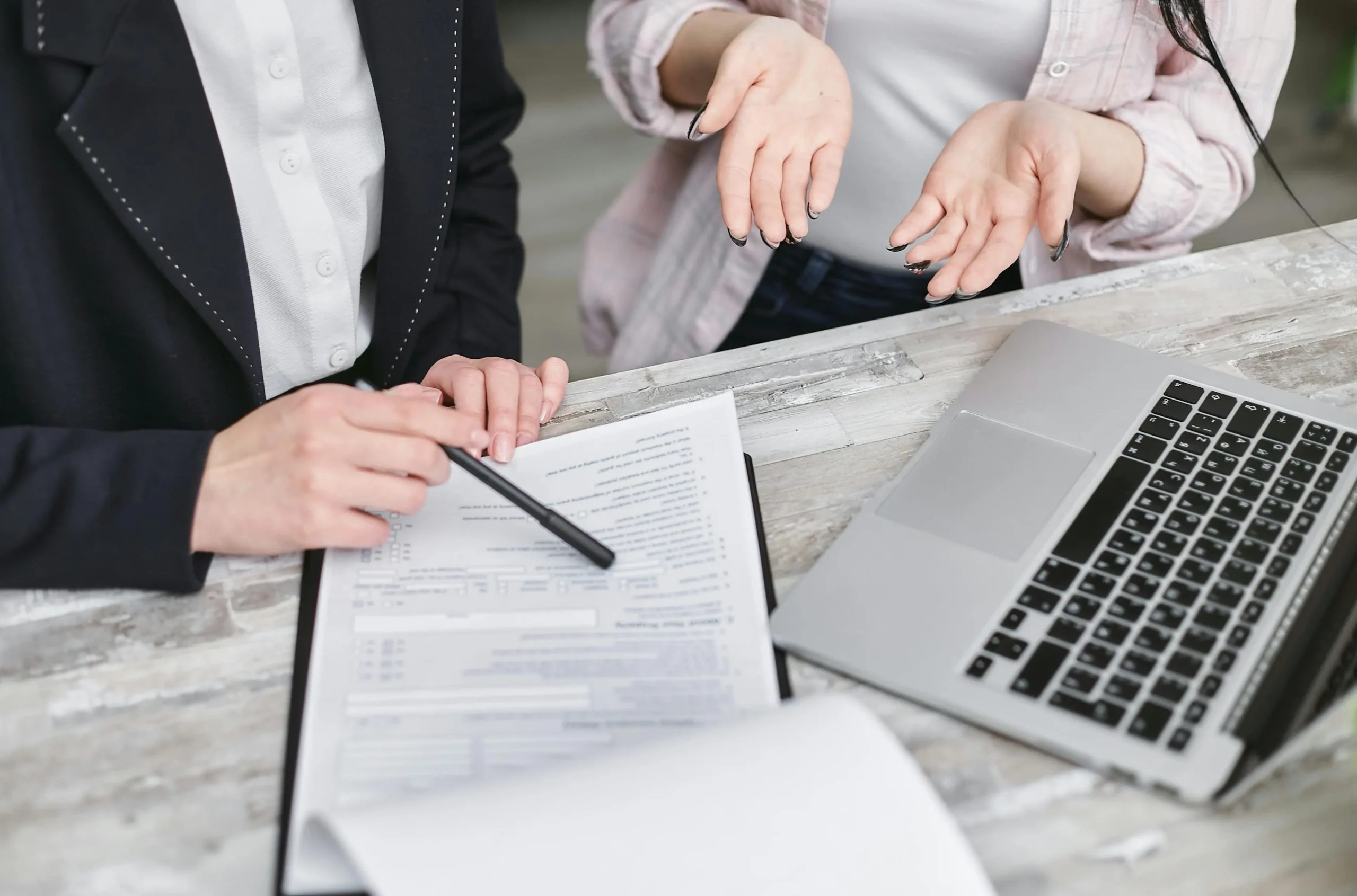 Personas revisando documentos o firmando un contrato, representando la planificación y los requisitos legales de un matrimonio
