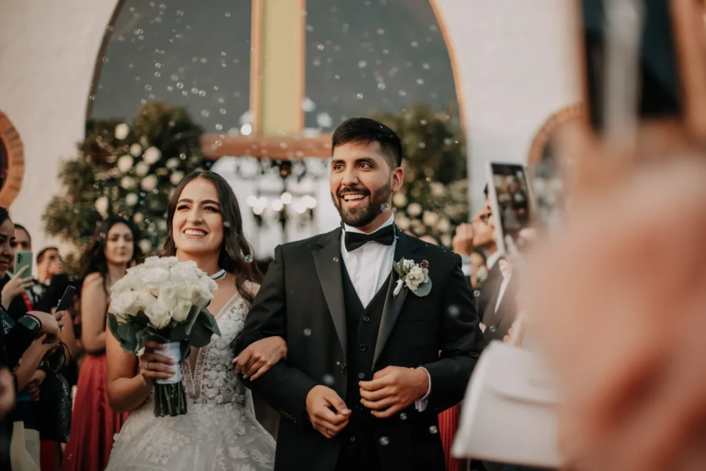 Novios sonriendo durante la salida de su ceremonia de boda en Cajicá.