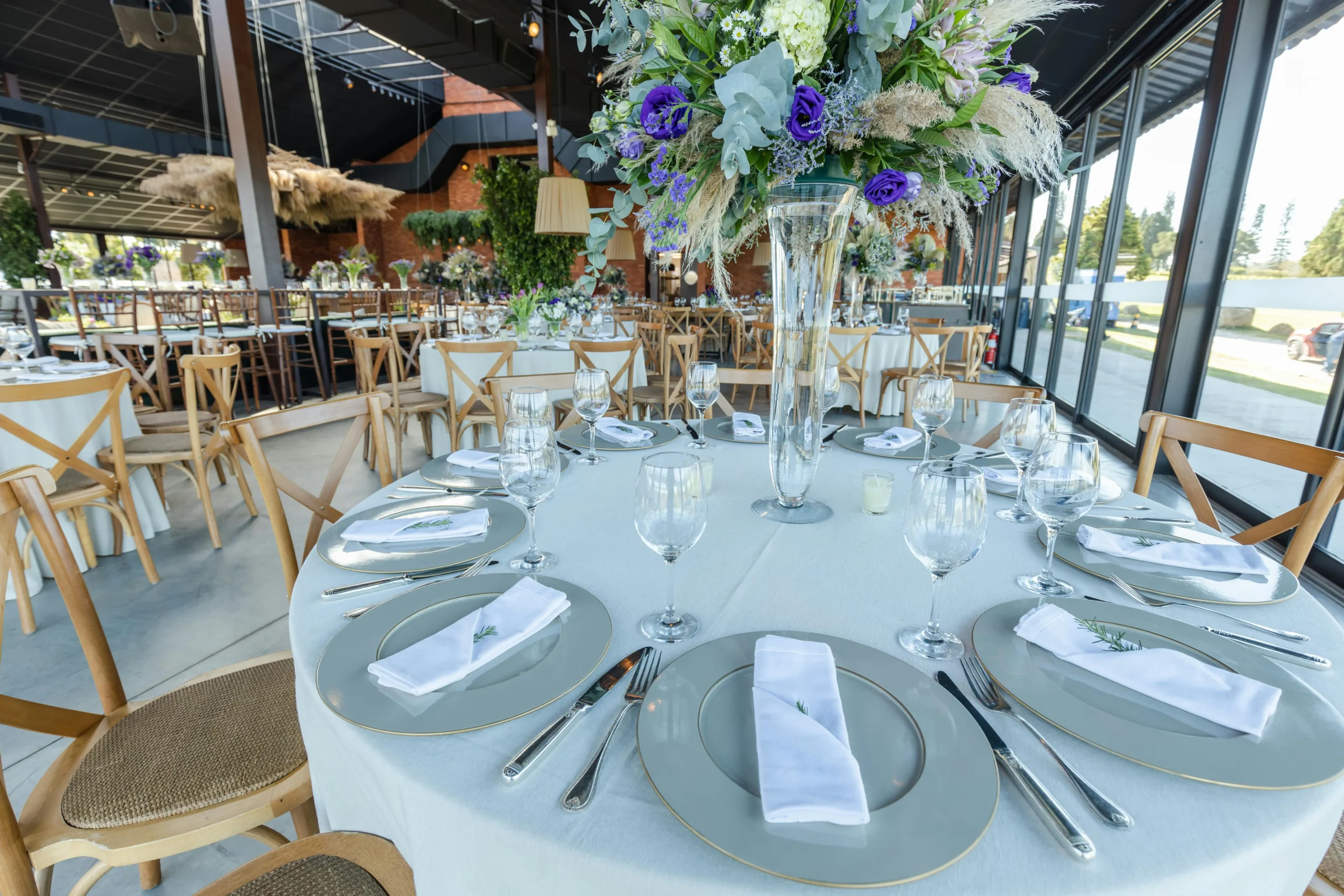 Mesa elegantemente decorada para una recepción en una moderna casa de eventos en Bogotá, destacando el menaje y un centro de mesa floral.