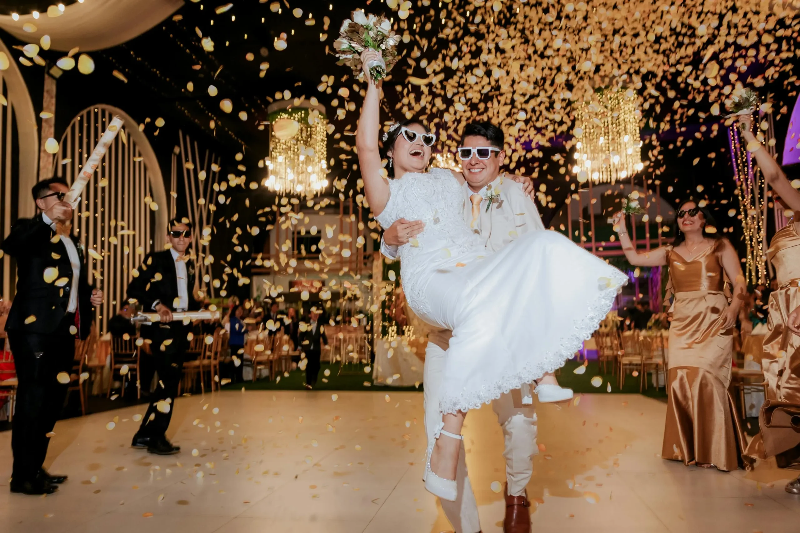 Novios celebrando en la pista de baile bajo una lluvia de confeti durante su fiesta de bod