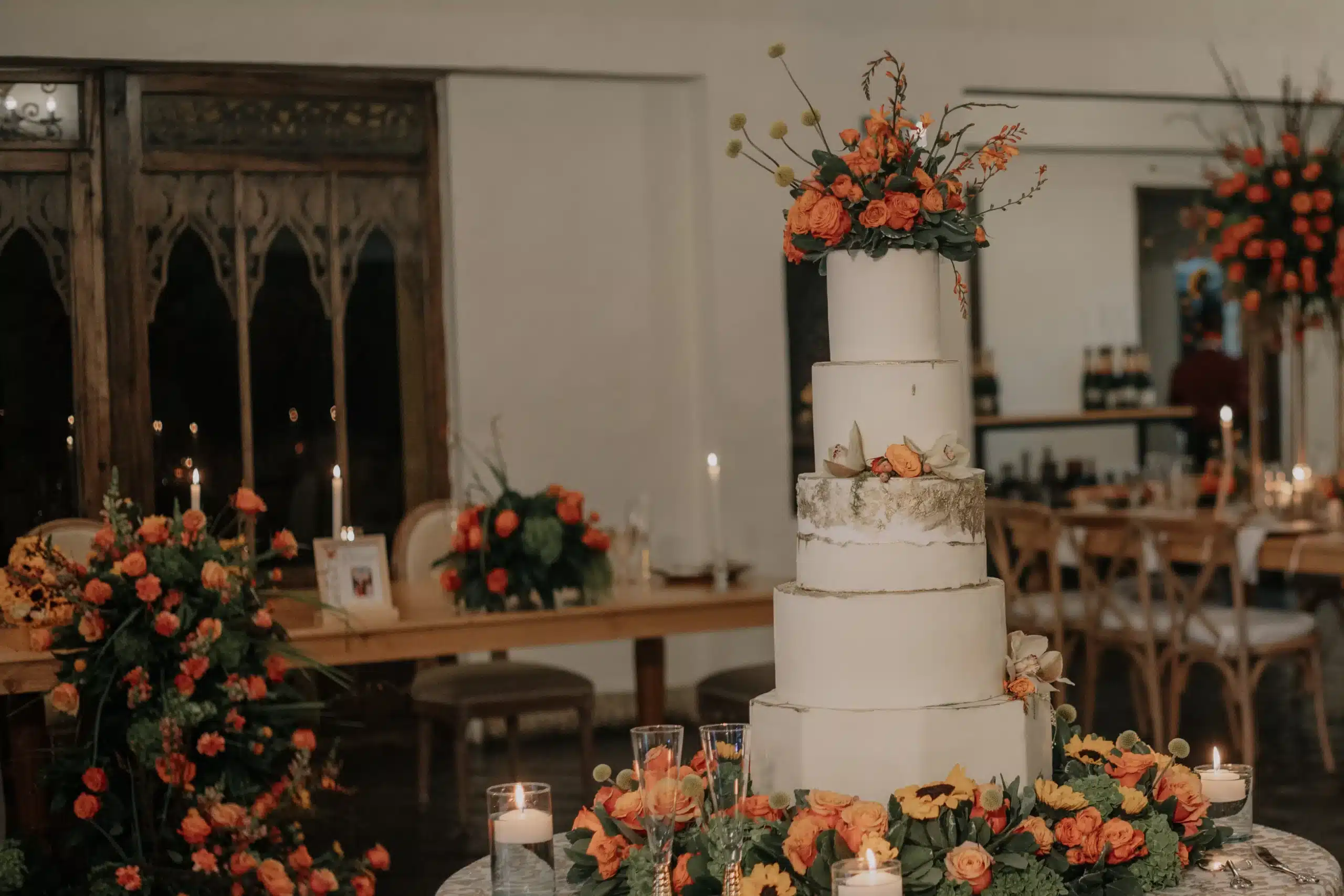 Espectacular pastel de bodas blanco de varios pisos, decorado con flores naturales para una elegante celebración de matrimonio en Bogotá. 