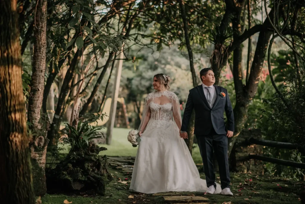 Pareja de recien casados tomandose fotos en un jardin de una hacienda de bodas en Tenjo