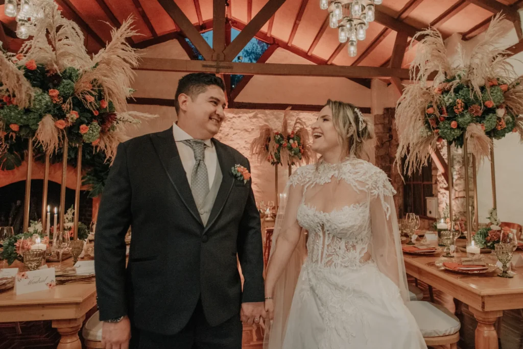 Momento íntimo y romántico de los novios durante la recepción de su matrimonio en Bogotá, junto al pastel de bodas.