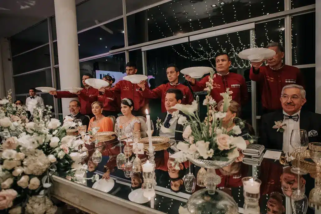 Impecable servicio de banquetes en una boda en Bogotá, con meseros atendiendo a los novios e invitados. 