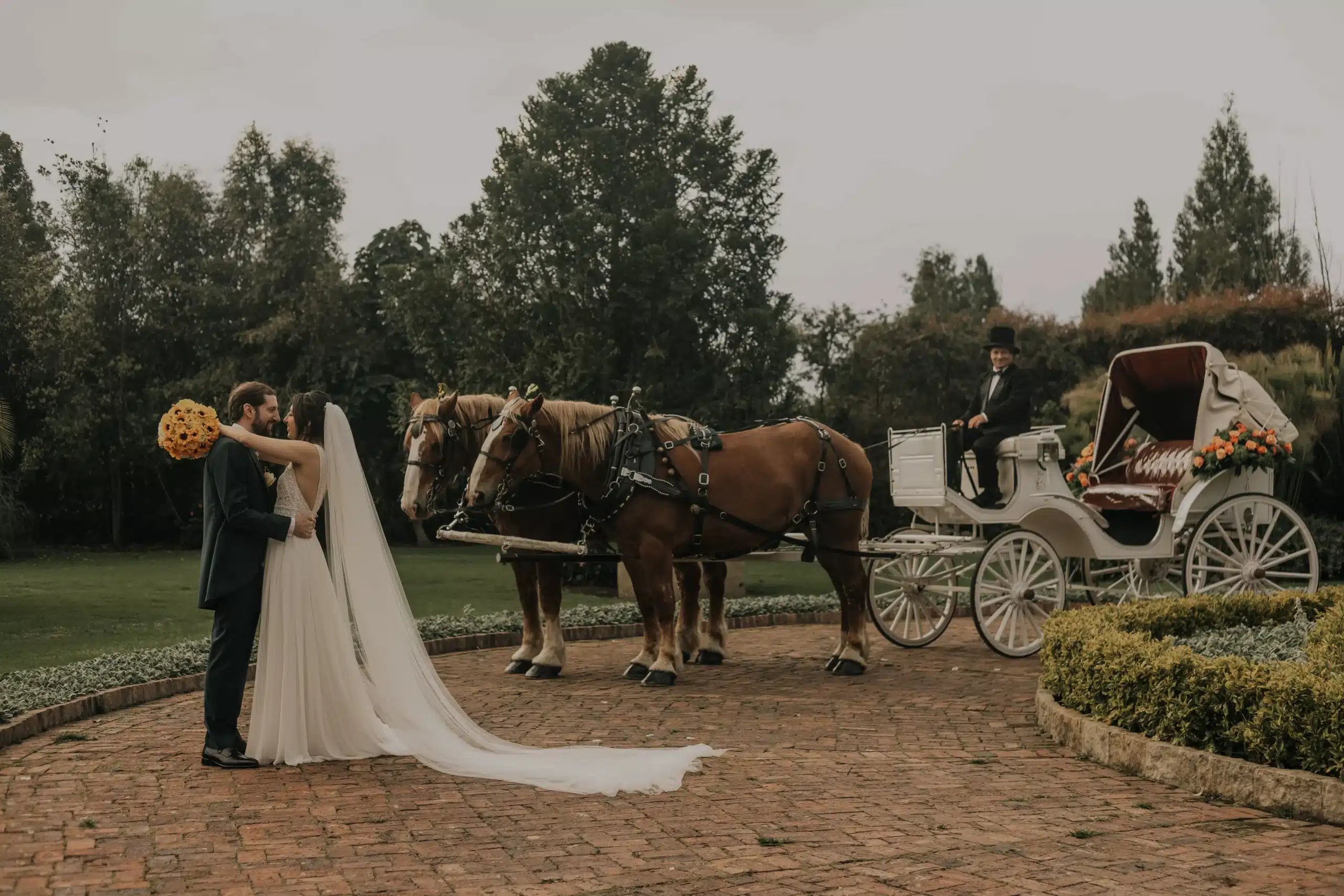 Novios junto a una carroza con caballos en su boda campestre de ensueño, un detalle único organizado por Eventos Bella Suiza.