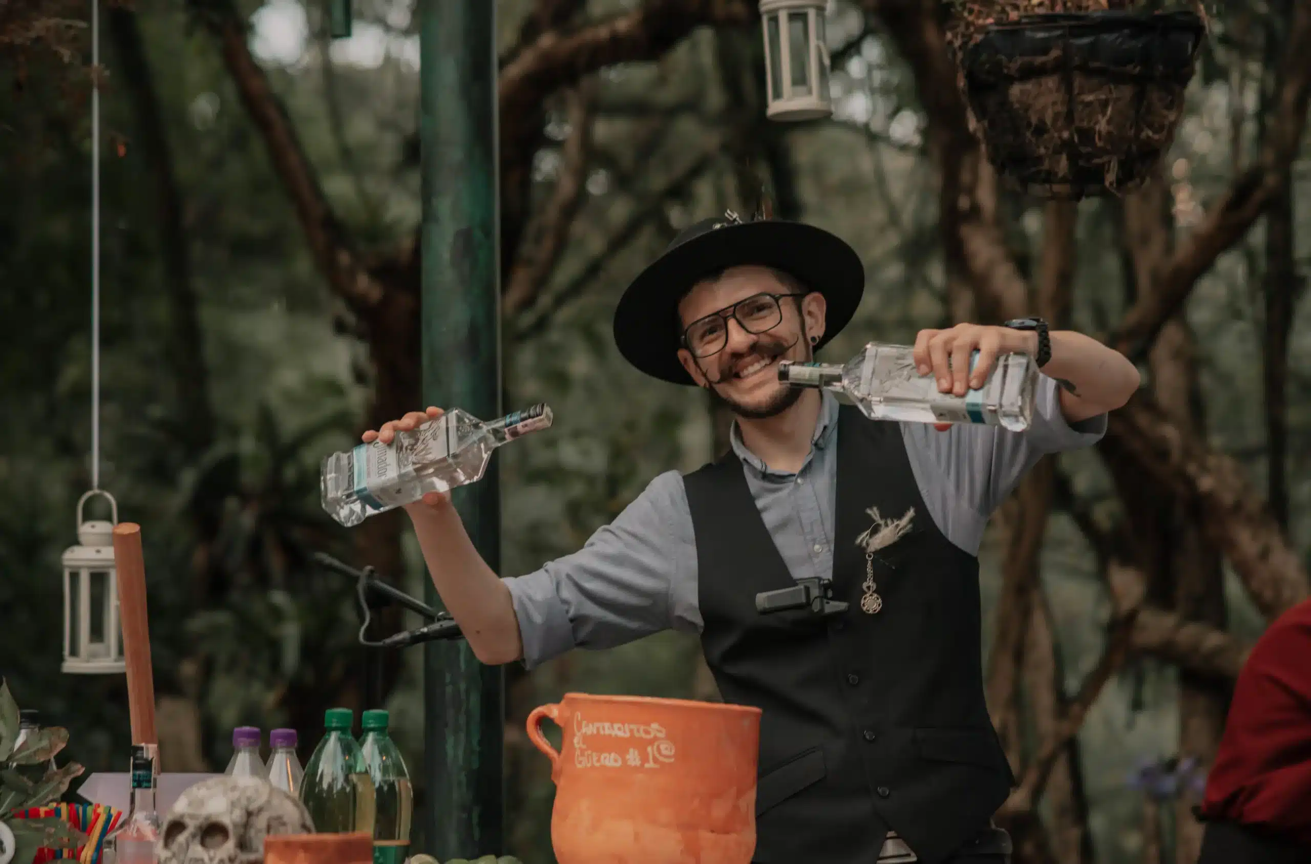 Barman preparando cócteles de autor en una estación de bebidas al aire libre para una boda