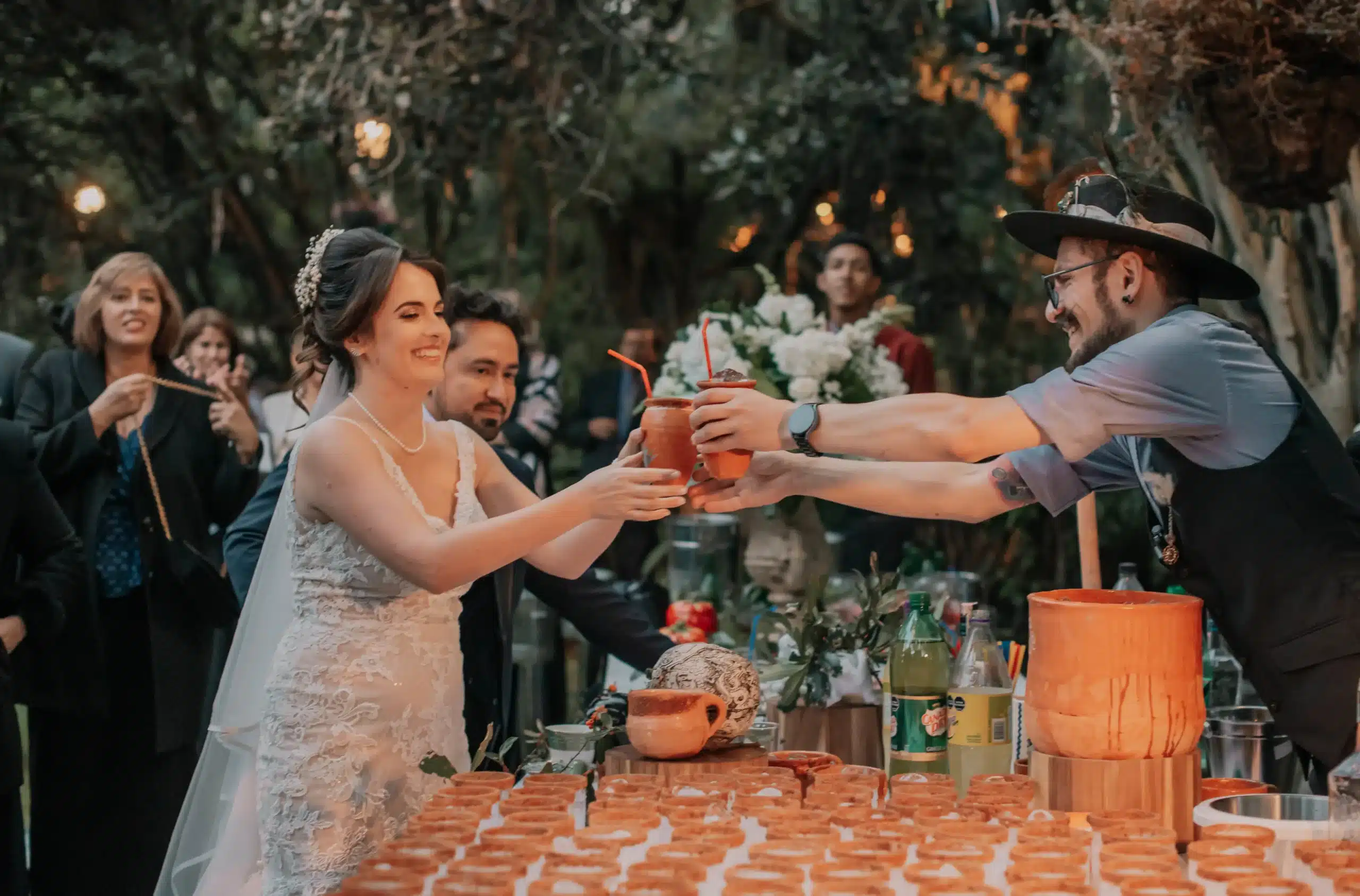 Novia disfrutando de la fiesta de su boda y recibiendo un cóctel en la barra, una experiencia coordinada por su wedding planner
